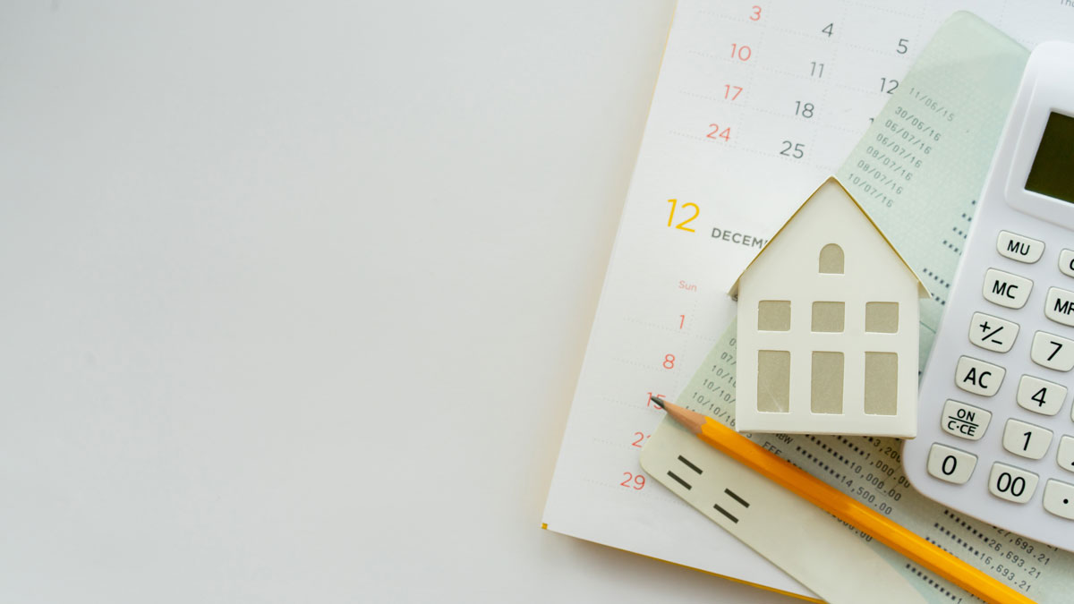 Top-down photo of stack of papers with calculator and pencil.