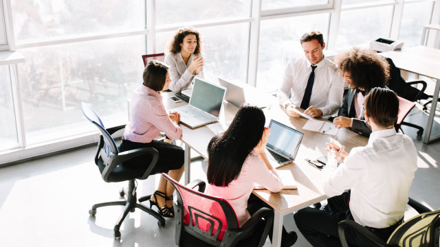 Group of coworkers sitting at a table working together.